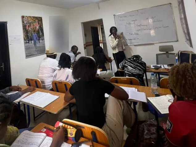Cours en groupe à M-Training Academy : une formatrice au tableau, les apprenants prennent des notes